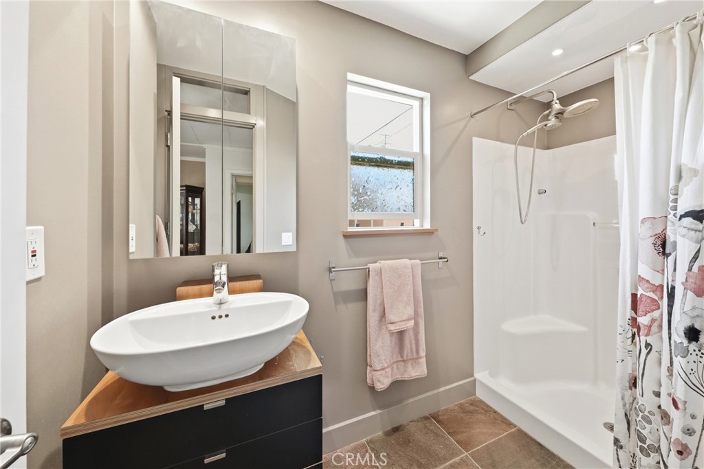 The guest 3/4 bathroom has been recently upgraded and features a modern vanity and a convenient walk-in shower offering - 1201 W Valencia Drive 13, Fullerton CA 92833 - photo 5