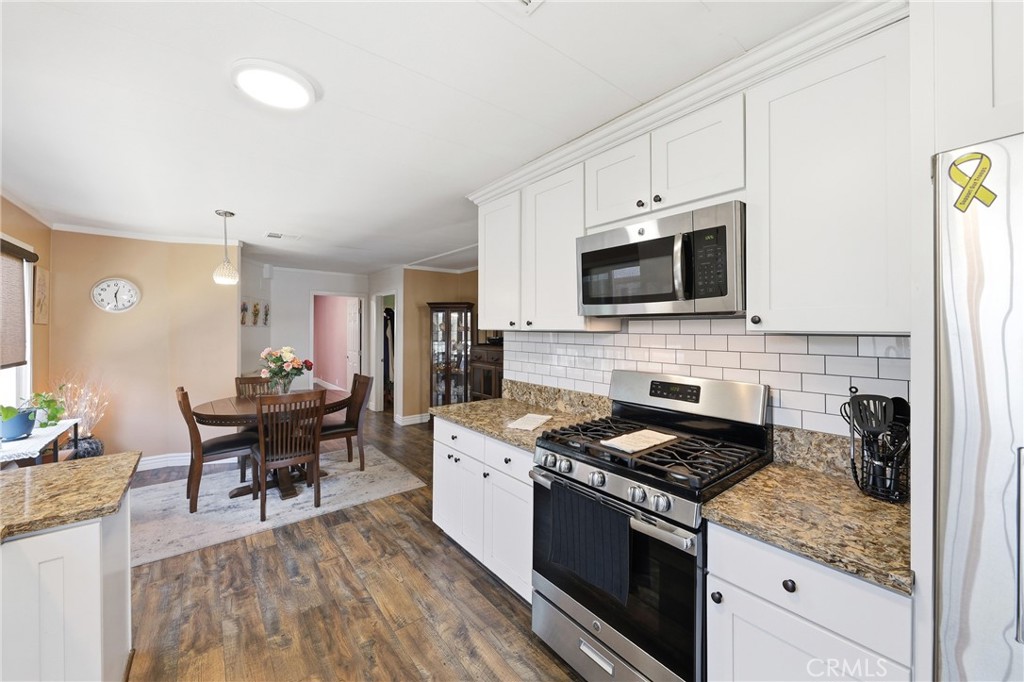 The kitchen is equipped with stainless steel appliances, including a microwave, self-cleaning oven, and refrigerator, of - 1201 W Valencia Drive 13, Fullerton CA 92833 - photo 14