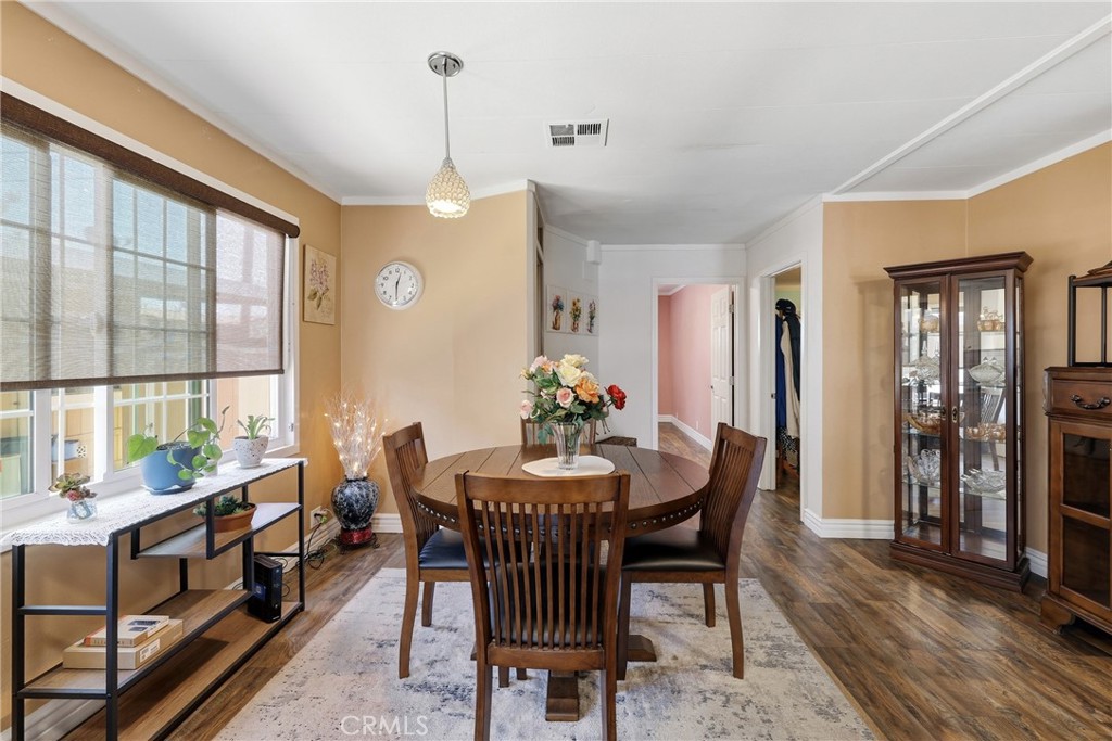The dining area is filled with abundant natural light and features dual-pane windows, window coverings, and gorgeous lam - 1201 W Valencia Drive 13, Fullerton CA 92833 - photo 17
