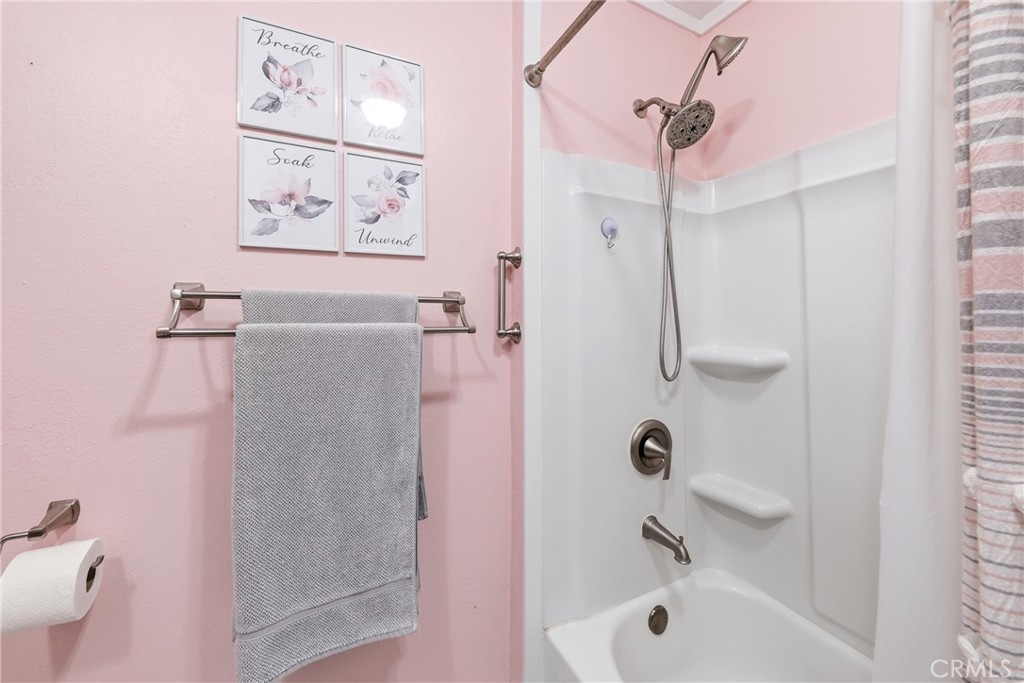 The primary bathroom features a recently upgraded full tub/shower combination with dual shower heads, offering comfort a - 1201 W Valencia Drive 13, Fullerton CA 92833 - photo 24