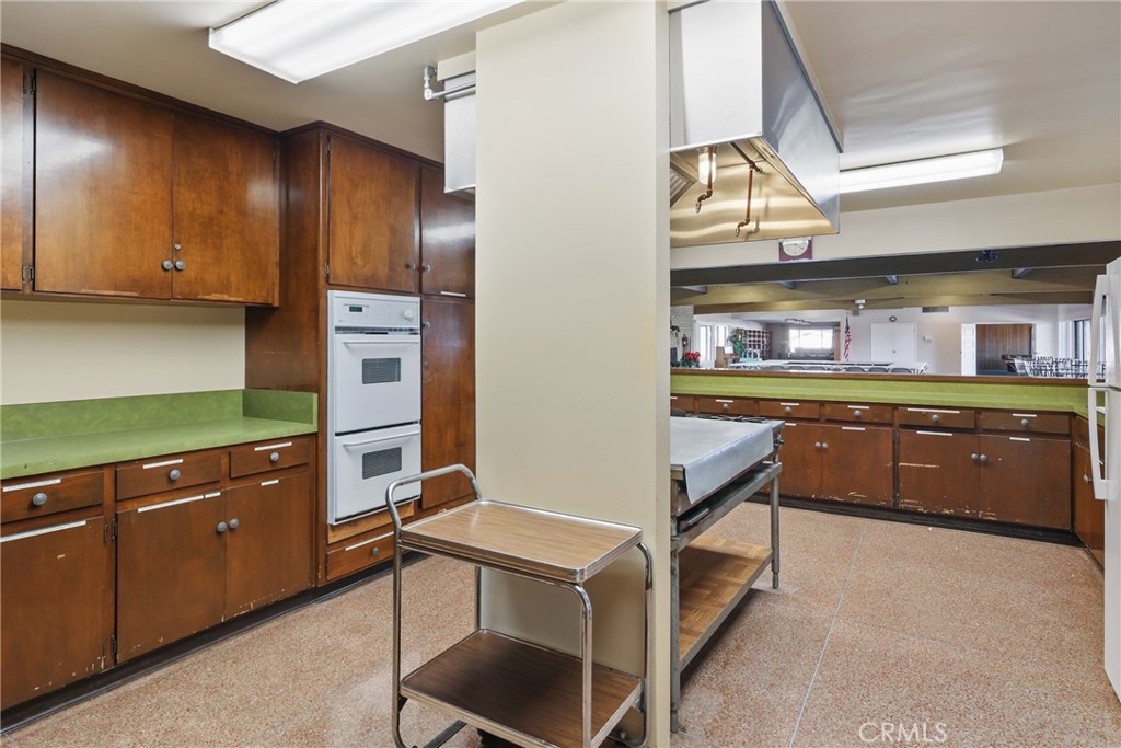 Spacious clubhouse kitchen with appliances, storage, and plenty of counter space. - 1201 W Valencia Drive 13, Fullerton CA 92833 - photo 32
