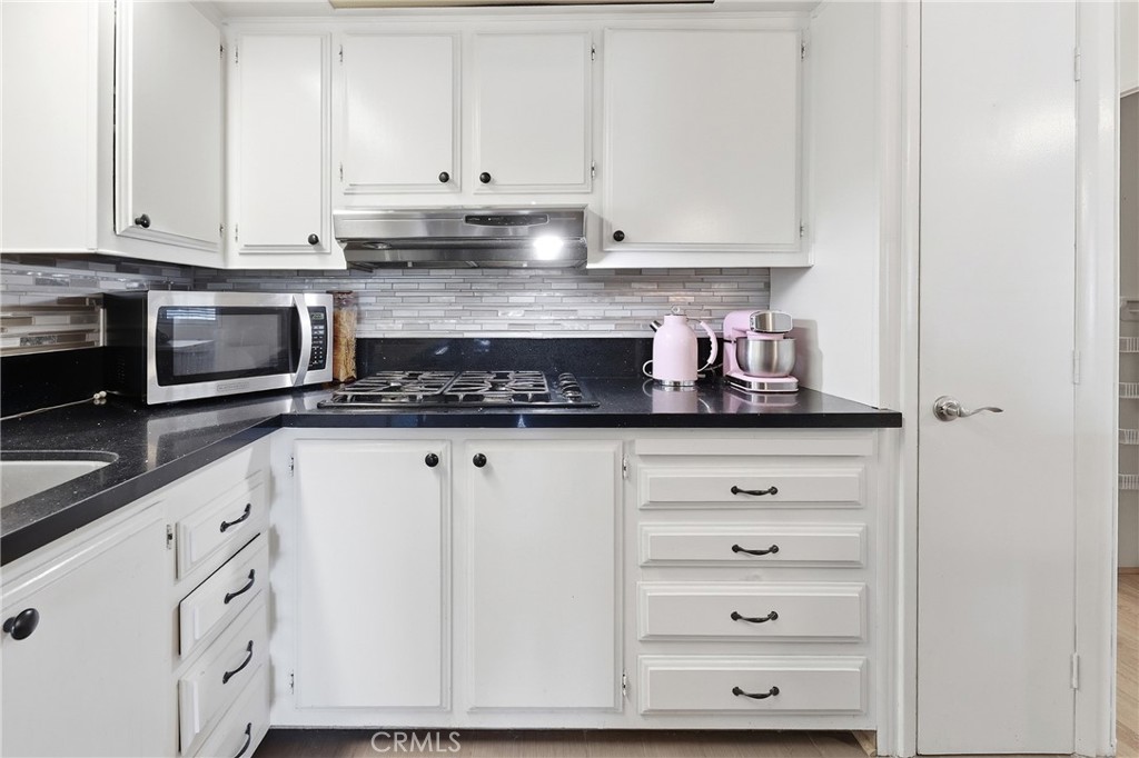 An abundance of storage and a stylish mosaic tile backsplash. - 1201 W Valencia Drive 69, Fullerton CA 92833 - photo 8