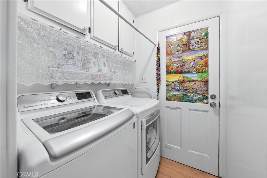 A spacious laundry room featuring a washer, dryer, ample storage, and convenient direct access to the carport. - 1201 W Valencia Drive 69, Fullerton CA 92833 - photo 11
