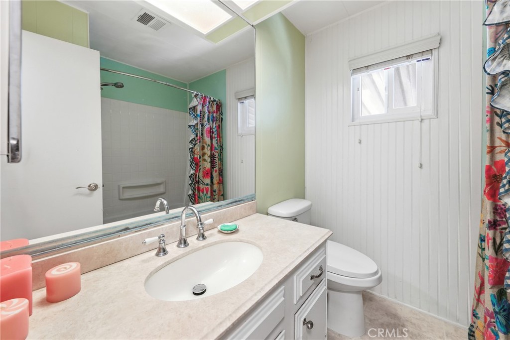 The guest bathroom features a full bath, shower in tub, and a modern bidet toilet. - 1201 W Valencia Drive 69, Fullerton CA 92833 - photo 14