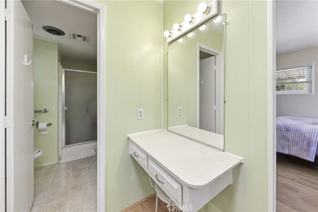 Another view of the vanity, 3/4 bath, and primary bedroom. - 1201 W Valencia Drive 69, Fullerton CA 92833 - photo 17