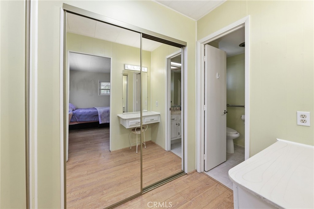 The primary bathroom features a spacious vanity and two mirrored closet doors, providing ample storage. - 1201 W Valencia Drive 69, Fullerton CA 92833 - photo 19