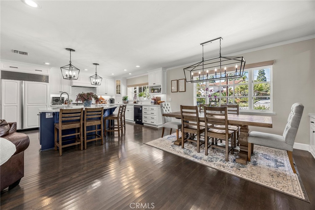 Open-concept kitchen and living area with rich wood flooring, abundant natural light and plenty of space for everyday li - 2100 Yucca Avenue, Fullerton CA 92835 - photo 9