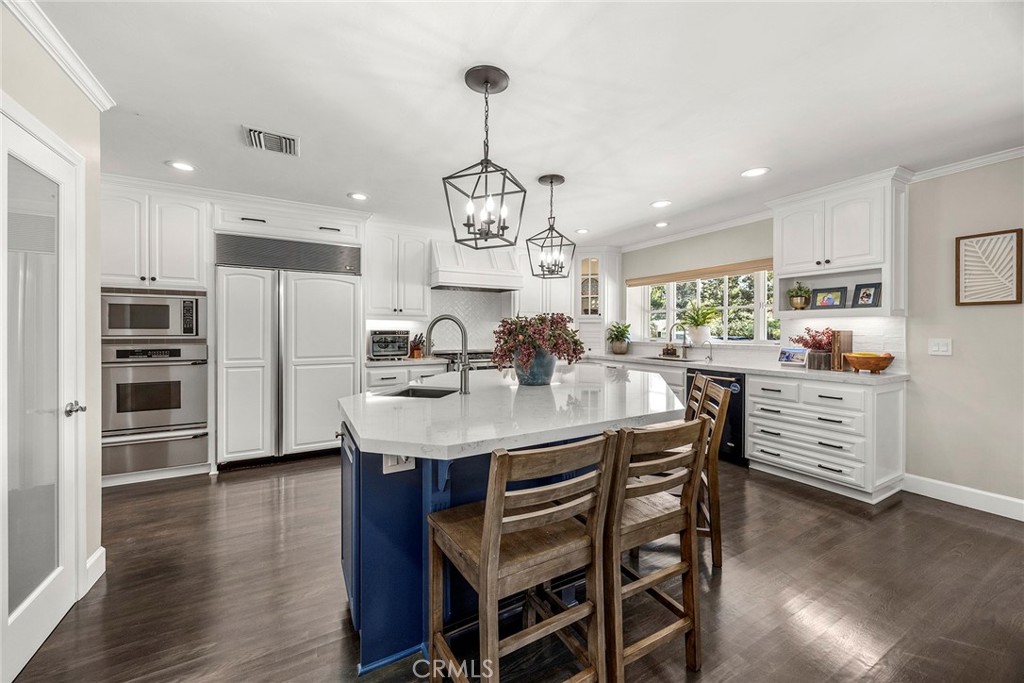 Beautifully remodeled kitchen featuring white cabinetry, a generous center island, stainless steel appliances, abundant - 2100 Yucca Avenue, Fullerton CA 92835 - photo 11