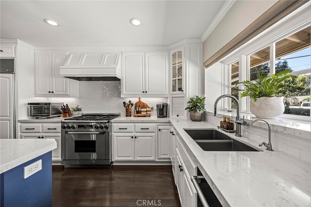 The beautifully updated kitchen features crisp white cabinetry, quartz countertops, stainless steel appliances, designer - 2100 Yucca Avenue, Fullerton CA 92835 - photo 14