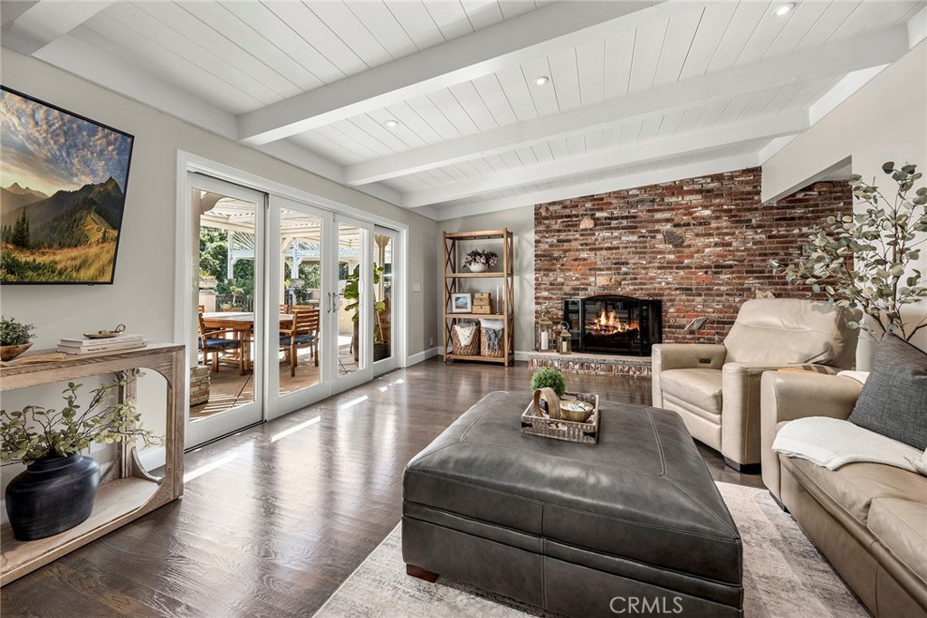 Spacious family room features a dramatic brick fireplace, beamed ceiling and direct access to the covered outdoor living - 2100 Yucca Avenue, Fullerton CA 92835 - photo 20