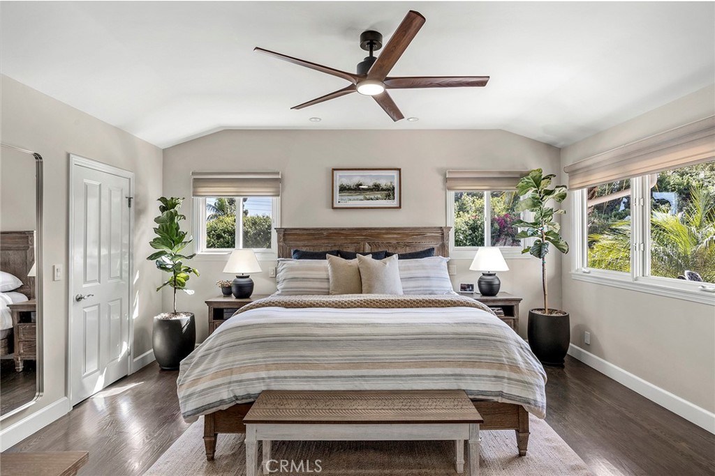 Spacious primary suite features a vaulted ceiling, rich wood flooring and abundant natural light overlooking the surroun - 2100 Yucca Avenue, Fullerton CA 92835 - photo 26