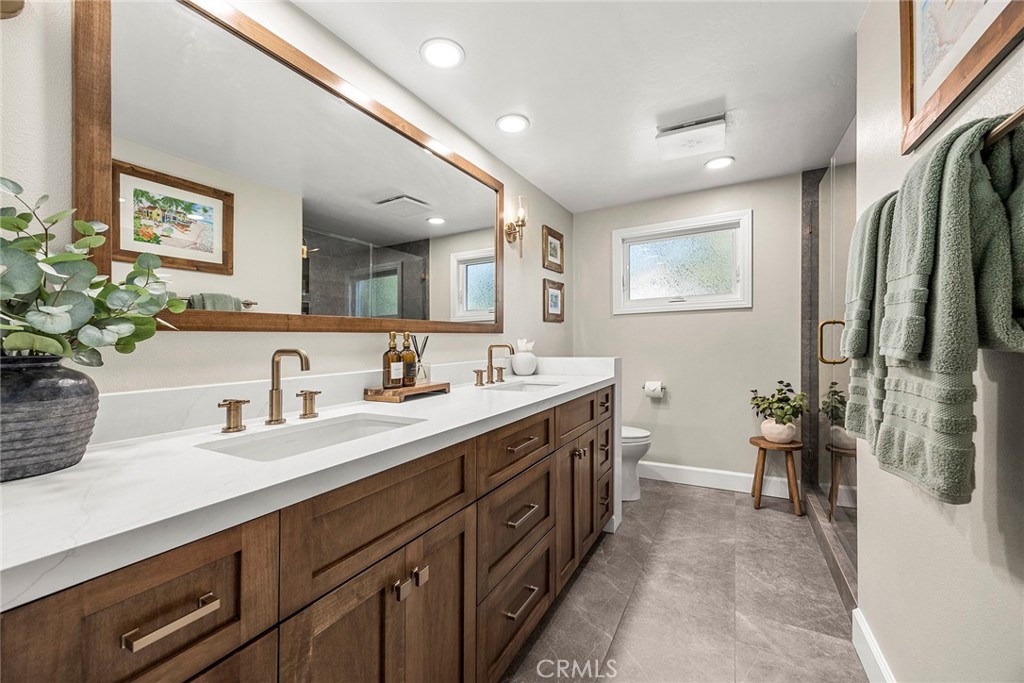 Beautifully updated hall bath features a dual-sink vanity, contemporary finishes and a glass-enclosed shower. - 2100 Yucca Avenue, Fullerton CA 92835 - photo 35