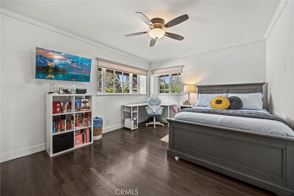 A generously sized secondary bedroom offers beautiful hardwood floors, abundant natural light, and plenty of space for a - 2100 Yucca Avenue, Fullerton CA 92835 - photo 38