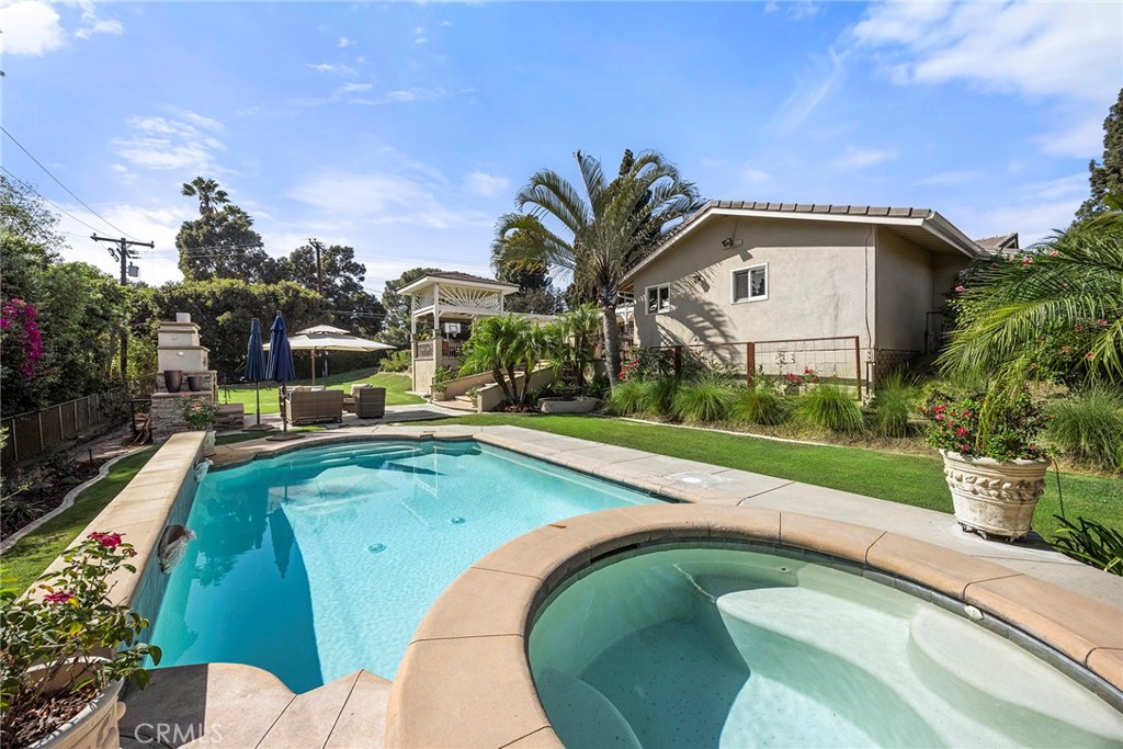 Resort-style backyard features a sparkling pool and elevated spa surrounded by mature landscaping for a private outdoor - 2100 Yucca Avenue, Fullerton CA 92835 - photo 45