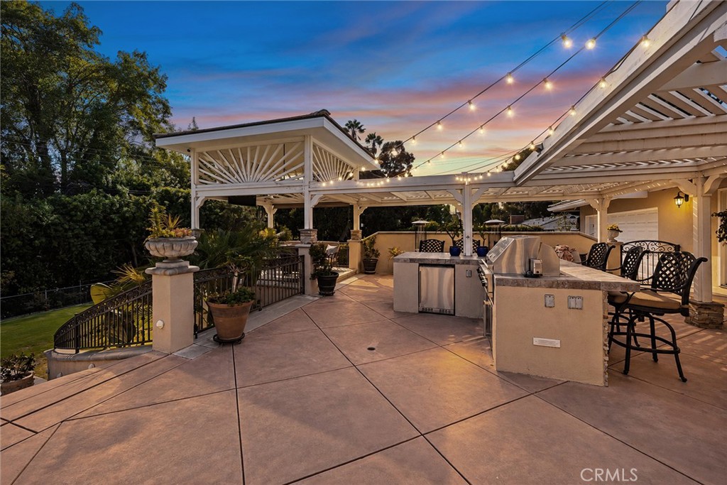 Dramatic twilight view showcases the outdoor kitchen, expansive patio and ambient café lighting. - 2100 Yucca Avenue, Fullerton CA 92835 - photo 52