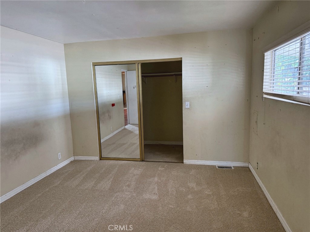 Second bedroom with mirrored closet doors and new carpet - 2851 Rolling Hills 187, Fullerton CA 92835 - photo 9