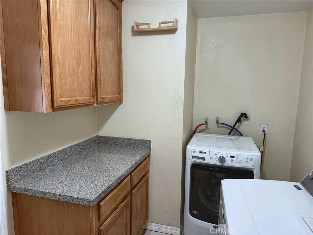 Separate laundry room with built-in cabinets and counter space - 2851 Rolling Hills 187, Fullerton CA 92835 - photo 11