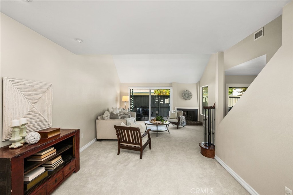 elax in the airy living room with soaring ceilings, a cozy fireplace and sliding doors to the patio. - 12632 Romaine Wy, Garden Grove CA 92845 - photo 4