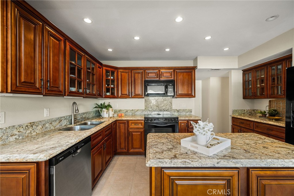 Inviting kitchen and dining area with a center island and easy access to the living room. - 12632 Romaine Wy, Garden Grove CA 92845 - photo 17
