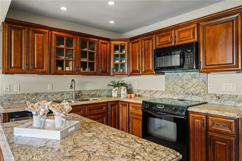 Beautifully appointed kitchen with rich wood cabinetry, granite countertops and generous storage. - 12632 Romaine Wy, Garden Grove CA 92845 - photo 18