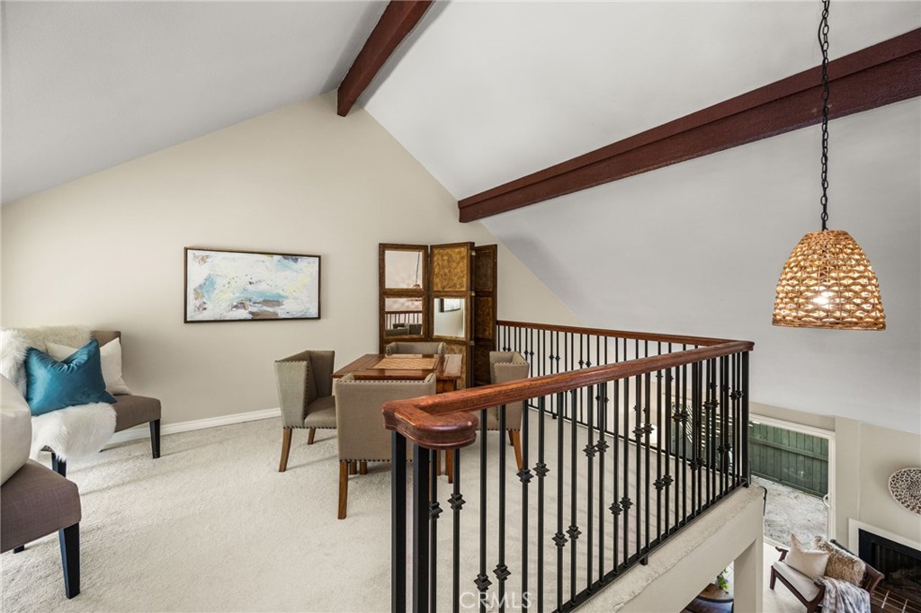 An elevated view of the office loft highlights its dramatic ceiling beams and open railing overlooking the living room. - 12632 Romaine Wy, Garden Grove CA 92845 - photo 28