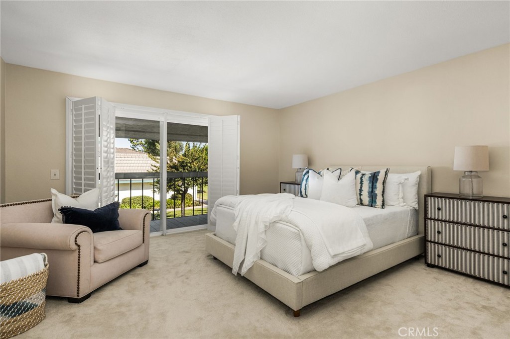 Spacious primary bedroom with plantation shutters and sliding doors opening to a private balcony. - 12632 Romaine Wy, Garden Grove CA 92845 - photo 31