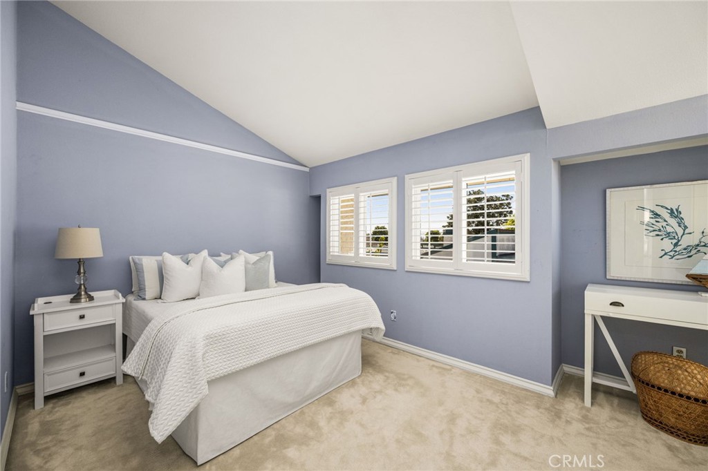 Inviting guest bedroom with vaulted ceilings, plantation shutters and soft blue walls. - 12632 Romaine Wy, Garden Grove CA 92845 - photo 37