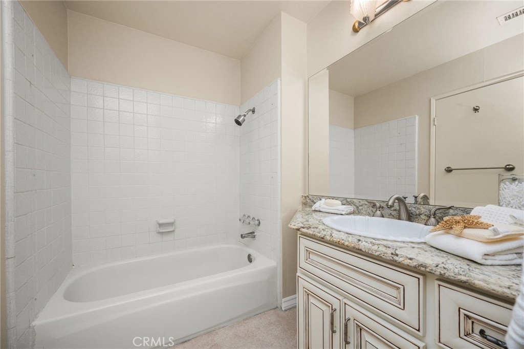 Guest bathroom includes a tub and shower combination, tiled surround and a beautifully detailed vanity. - 12632 Romaine Wy, Garden Grove CA 92845 - photo 40