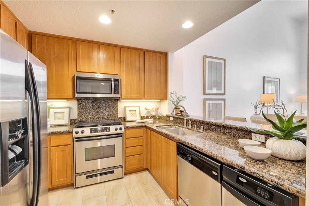 Functional spaced Kitchen with granite countertops and modern stainless steel appliances, with recessed lights - 12664 Chapman Avenue 1402, Garden Grove CA 92840 - photo 10
