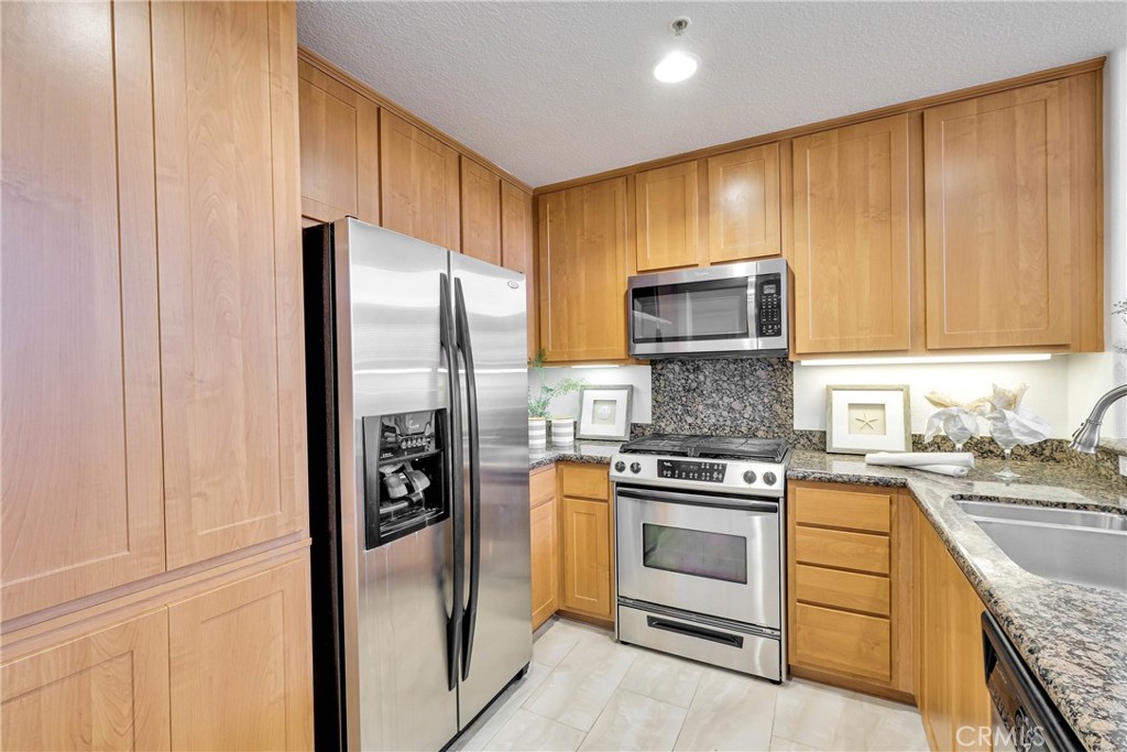 Functional spaced Kitchen with granite countertops and modern stainless steel appliances, with recessed lights - 12664 Chapman Avenue 1402, Garden Grove CA 92840 - photo 11