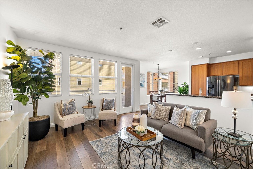 Open floor plan with multiple windows for natural light in your living room, leading to the dining and kitchen area - 12668 Chapman Avenue 2301, Garden Grove CA 92840 - photo 1