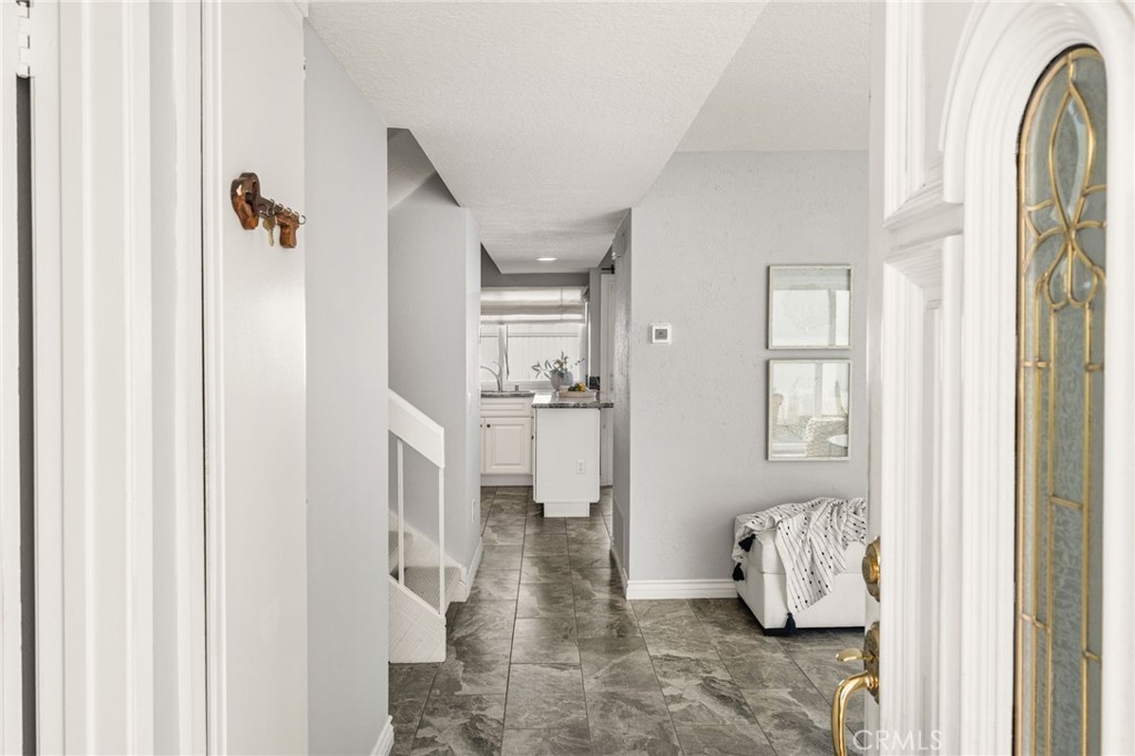 Welcome inside! A decorative glass front door opens to an inviting entry with attractive tile flooring. - 6931 Danvers Dr, Garden Grove CA 92845 - photo 4