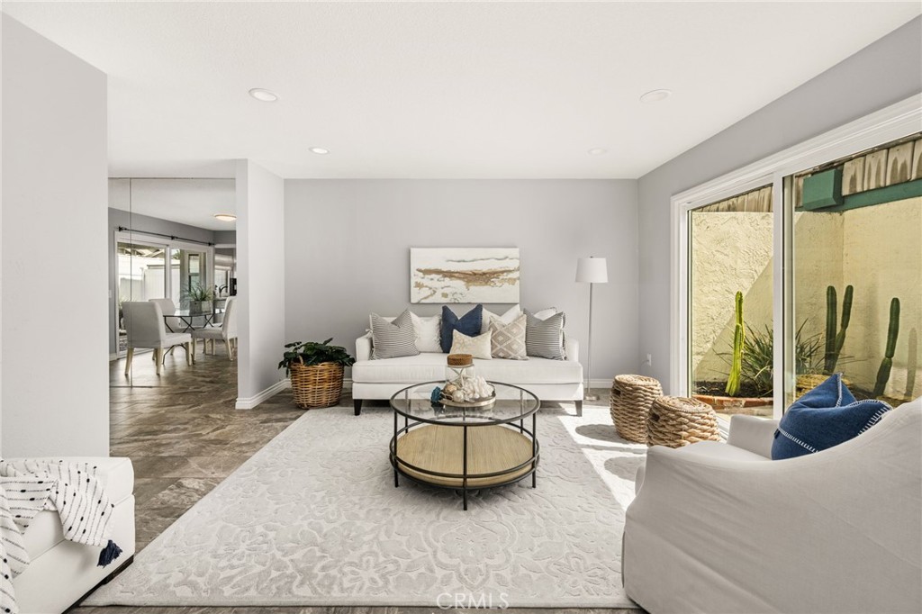 Spacious living room filled with natural light, with sliding glass doors opening to a private outdoor retreat. - 6931 Danvers Dr, Garden Grove CA 92845 - photo 5