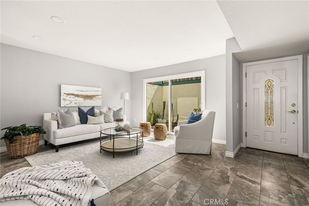 An airy living room welcomes you with neutral finishes, generous seating space, and easy outdoor access. - 6931 Danvers Dr, Garden Grove CA 92845 - photo 7