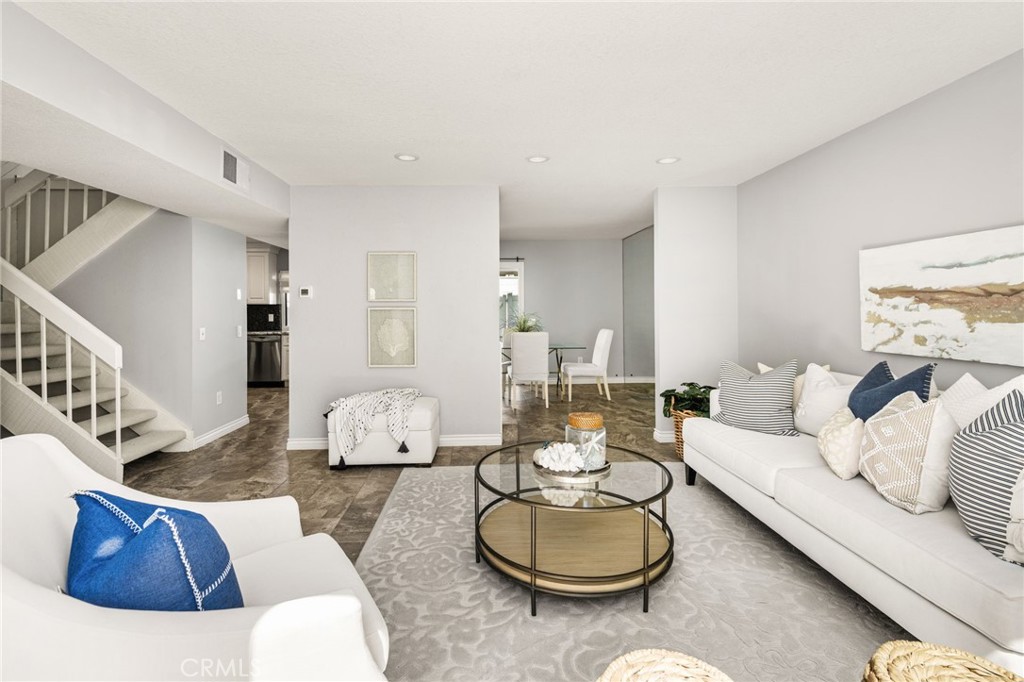 An inviting main level connects the spacious living room with the dining area and kitchen beyond. - 6931 Danvers Dr, Garden Grove CA 92845 - photo 11