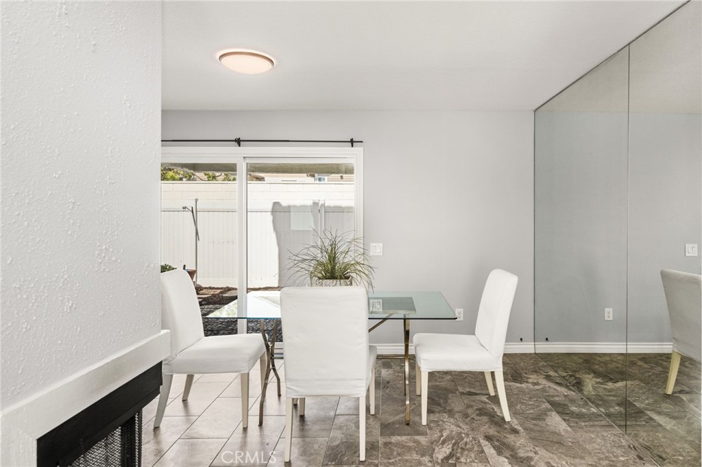 A delightful dining area features a mirrored accent wall and sliding glass doors to the patio. - 6931 Danvers Dr, Garden Grove CA 92845 - photo 13