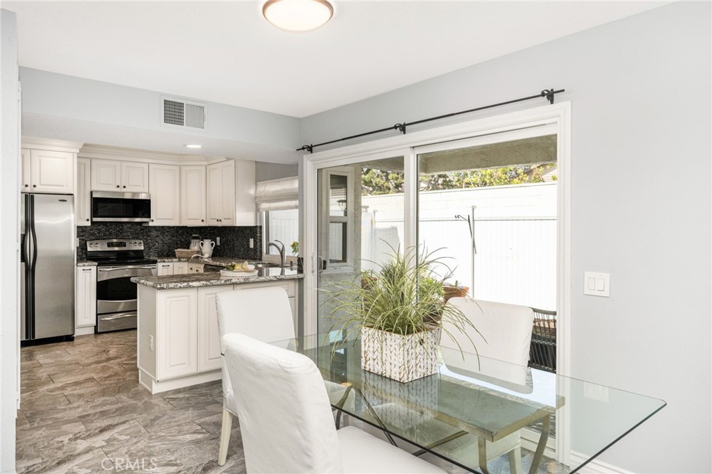 7 Enjoy easy entertaining with a dining area conveniently located beside the kitchen and outdoor patio. - 6931 Danvers Dr, Garden Grove CA 92845 - photo 14