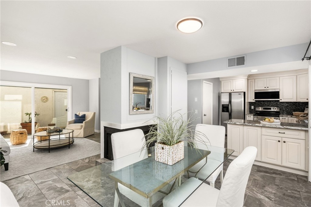 A cozy fireplace adds warmth and charm to the dining area, beautifully connected to the main living spaces. - 6931 Danvers Dr, Garden Grove CA 92845 - photo 15