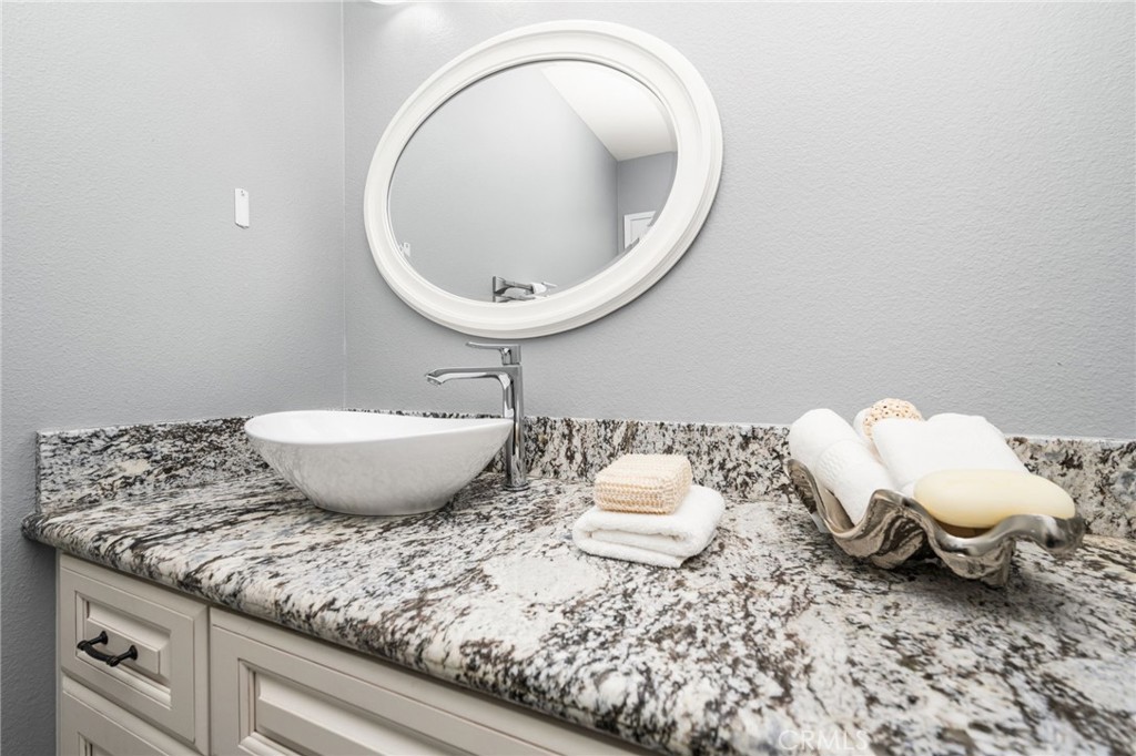 Guest bathroom Charming guest bathroom featuring a granite-topped vanity, vessel sink, and classic white cabinetry. - 6931 Danvers Dr, Garden Grove CA 92845 - photo 29