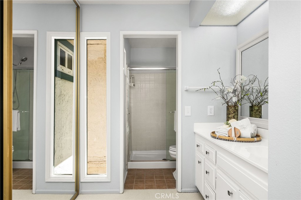 Bath: The adjoining primary bath offers a spacious vanity with ample storage, a large mirror, and a separate walk-in sho - 6931 Danvers Dr, Garden Grove CA 92845 - photo 36