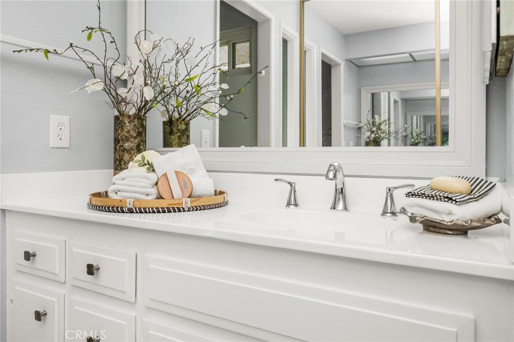 Primary suite Spacious vanity and dressing area flow into the primary bedroom, showcasing its beautiful stone accent wal - 6931 Danvers Dr, Garden Grove CA 92845 - photo 38