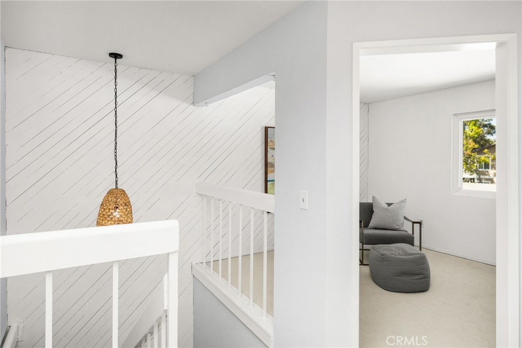 – Stairwell landing Airy upstairs landing accented by white paneling, an open railing, and a decorative pendant light. - 6931 Danvers Dr, Garden Grove CA 92845 - photo 41