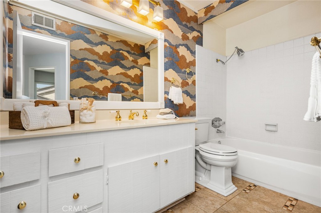 Guest bathroom Upstairs guest bath offers a tub/shower combination, spacious white vanity, and a distinctive decorative - 6931 Danvers Dr, Garden Grove CA 92845 - photo 44