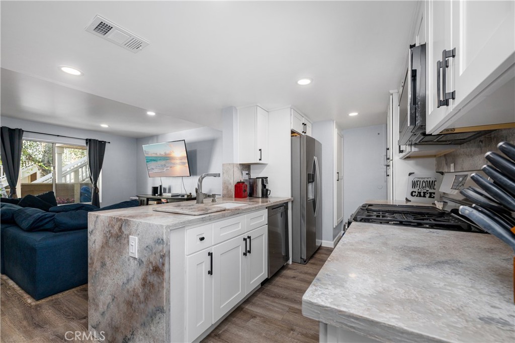 View from. kitchen into living room. Large rectangular sink, new white cabinets with soft closing doors and drawers. dis - 6971 Knollcrest #48 48, Garden Grove CA 92845 - photo 14