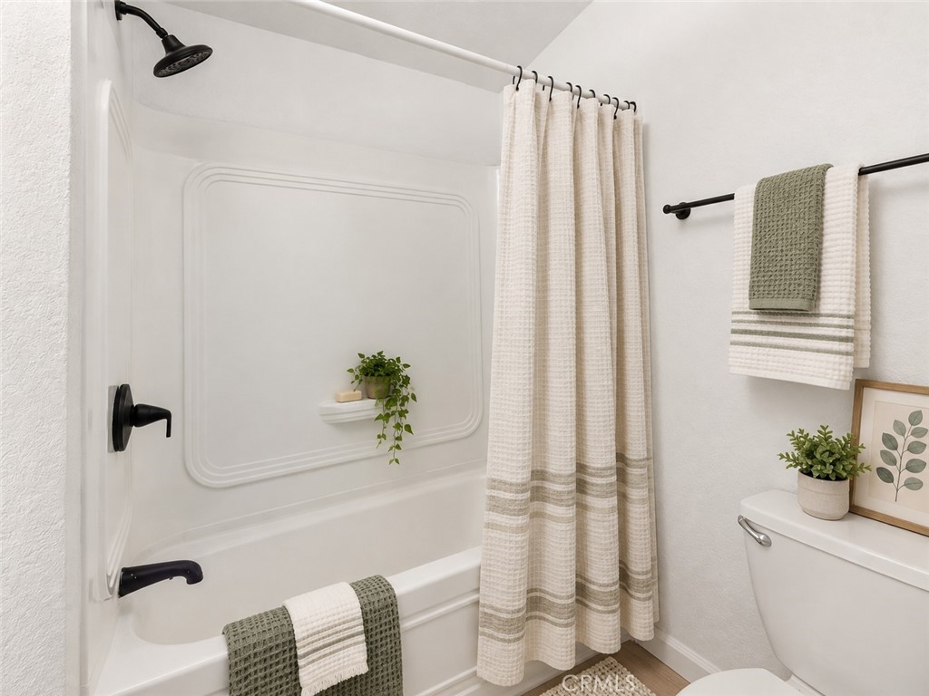 Bathroom tub with neutral curtain - 7887 Lampson Ave Avenue 10, Garden Grove CA 92841 - photo 16