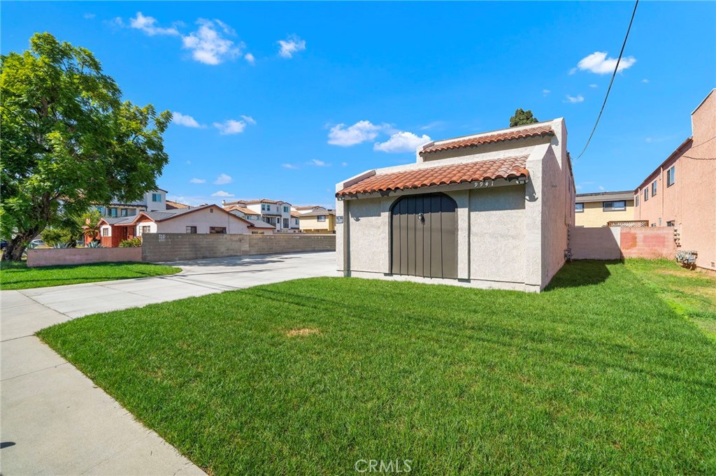 A lush front lawn frames the garage wing and highlights the property’s spacious street frontage. - 9941 11th Street, Garden Grove CA 92844 - photo 3