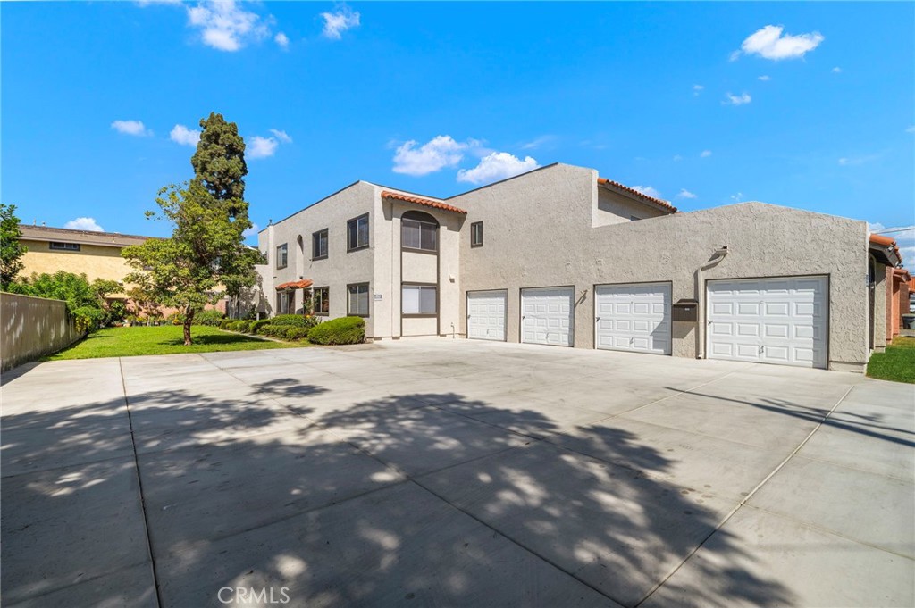 The expansive paved driveway offers ample maneuvering space in front of the building and garages. - 9941 11th Street, Garden Grove CA 92844 - photo 5