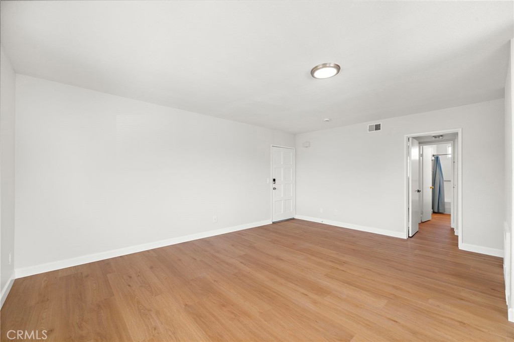 Natural light brightens the generous living room, where wood-look flooring creates a cohesive, welcoming finish. - 9941 11th Street, Garden Grove CA 92844 - photo 10