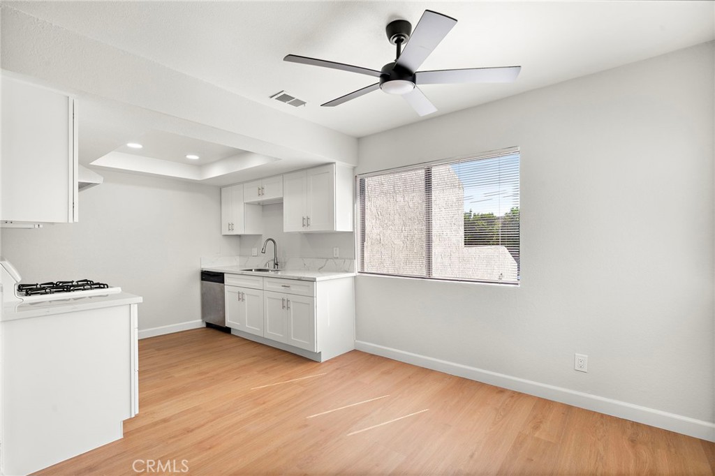 A ceiling fan anchors the dining area beside the remodeled kitchen and its convenient breakfast counter. - 9941 11th Street, Garden Grove CA 92844 - photo 12