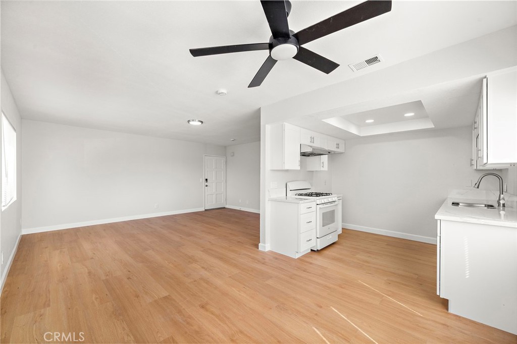 The open dining area flows easily into the kitchen, with a ceiling fan and matching wood-look flooring throughout. - 9941 11th Street, Garden Grove CA 92844 - photo 13